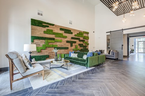 a living room with a green couch and a brick wall